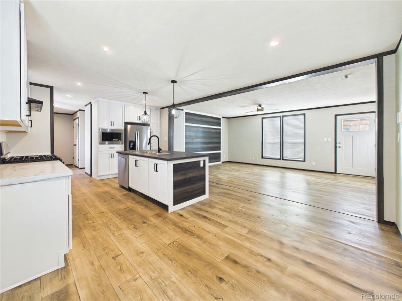 Kitchen & Living Area – Open-concept kitchen with large center island, modern cabinetry, stainless steel appliances, and seamless flow into the living area—ideal for everyday living and entertaining.
