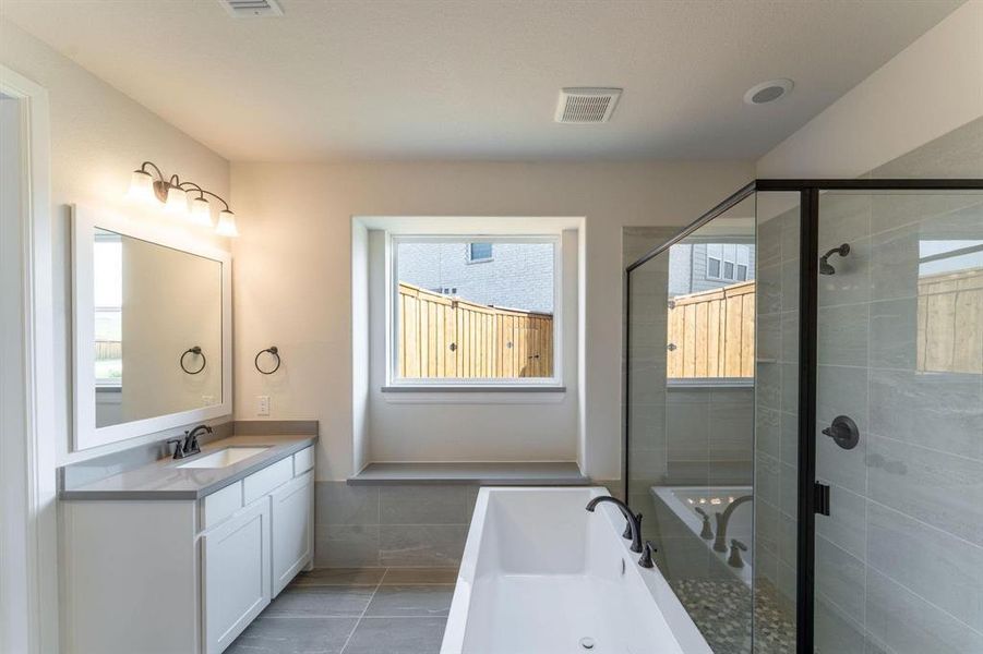 Bathroom with plus walk in shower, vanity, and tile patterned flooring