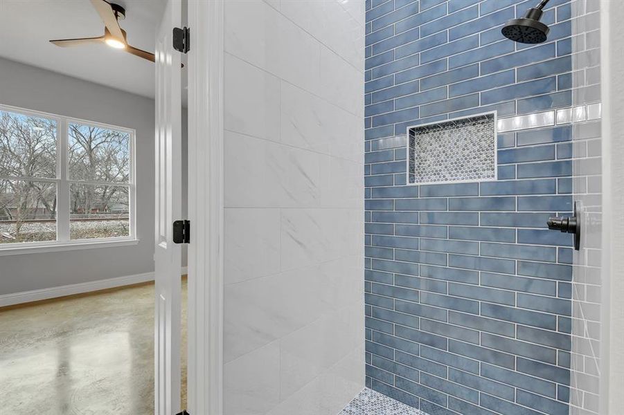 Full bath with a tile shower, concrete flooring, and a ceiling fan
