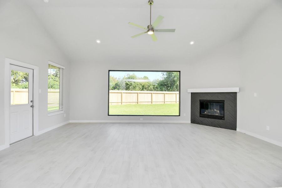 Family room flooded with natural light through the expansive window.  The premium tile flooring adds a touch of luxury to the space, creating the perfect setting for relaxing moments and cherished gatherings with loved ones. Sample photo of completed home with similar floor plan. Actual colors and selections may vary.