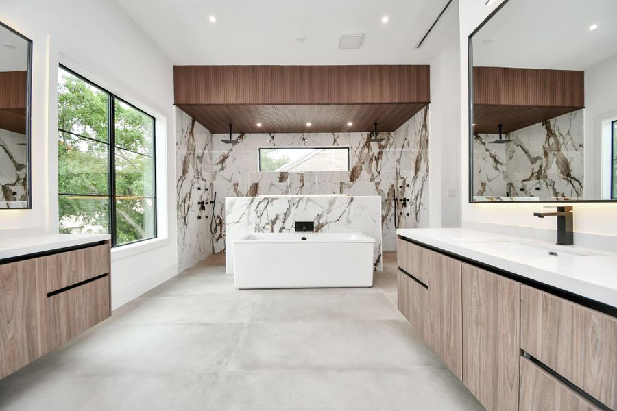 Luxurious primary bathroom retreat. Natural light cascades through large windows, illuminating every exquisite detail. Relax and unwind in the oversized soaking tub, surrounded by custom wood detailing that exudes elegance. The shower area boasts dual rain shower heads, body jets, and intricate built-in niches, enhanced by LED lights for a spa-like ambiance. Elevate your daily routine in this haven of opulence and tranquility. Luxurious primary bathroom retreat. Natural light cascades through large windows, illuminating every exquisite detail. Relax and unwind in the oversized soaking tub, surrounded by custom wood detailing that exudes elegance. The shower area boasts dual rain shower heads, body jets, and intricate built-in niches, enhanced by LED lights for a spa-like ambiance. Elevate your daily routine in this haven of opulence and tranquility.