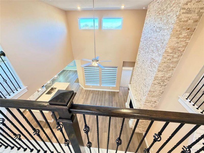 Staircase featuring wood finished floors and a ceiling fan Staircase featuring wood finished floors and a ceiling fan