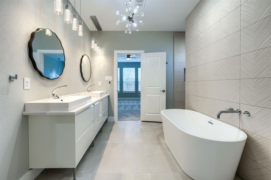 Bathroom featuring ceiling fan, a bath, tile patterned floors, vanity, and tile walls