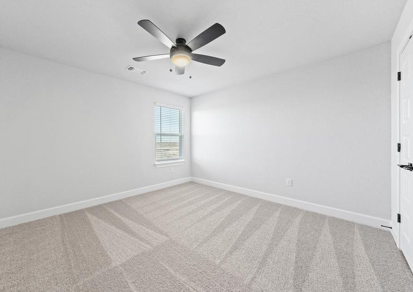 Take a look at the first secondary bedroom featuring plush carpets, a large window, and double doors to the closet.