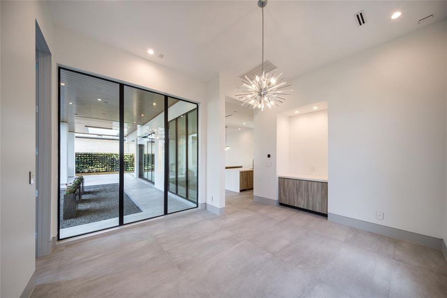 Turn an empty corner conveniently positioned next to your kitchen into a cozy modern breakfast nook. Offering abundant natural light flowing in and creating a lush garden view. Built-in buffet server and elegant crystal chandelier.