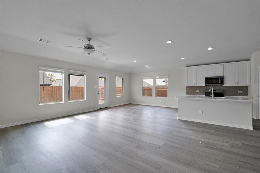 Unfurnished living room featuring light wood-style floors, recessed lighting, and a ceiling fan Unfurnished living room featuring light wood-style floors, recessed lighting, and a ceiling fan
