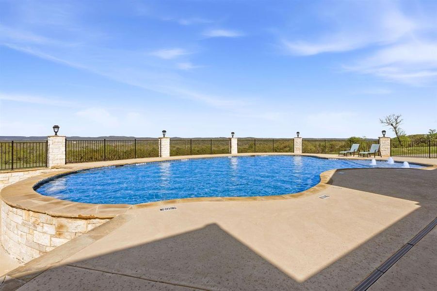 An inviting in-ground pool offers serene views of the surrounding hills, perfect for outdoor leisure.
