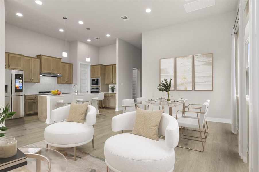 Living room featuring recessed lighting, light wood finished floors, a towering ceiling, and baseboards