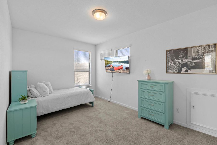 Soft carpeting underfoot and multiple windows define this versatile secondary bedroom space.