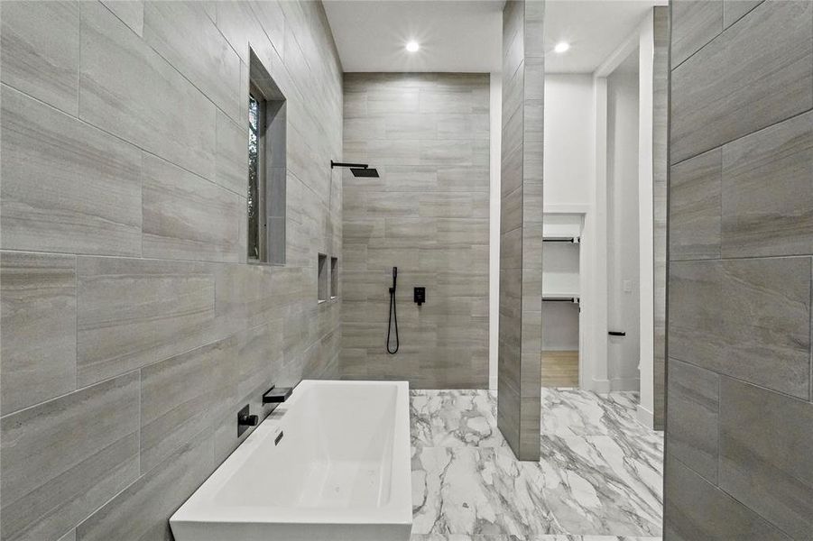 Bathroom featuring tile walls, sink, and a tile shower