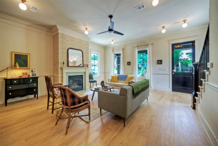 A welcoming living room features a classic fireplace and lustrous hardwood flooring, ideal for entertaining.