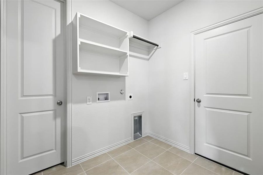 Laundry room with hookup for a gas dryer, light tile patterned floors, hookup for a washing machine, and hookup for an electric dryer