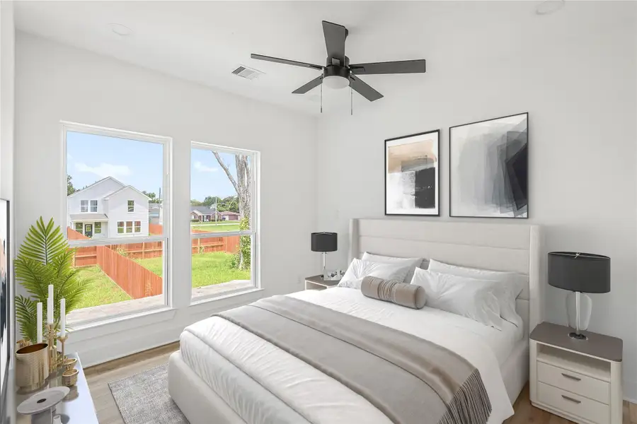 Alternate view of the fourth bedroom highlighting the large windows that fill the space with natural light. This bright and inviting room offers a warm, comfortable atmosphere—perfect for guests, family, or a private retreat.