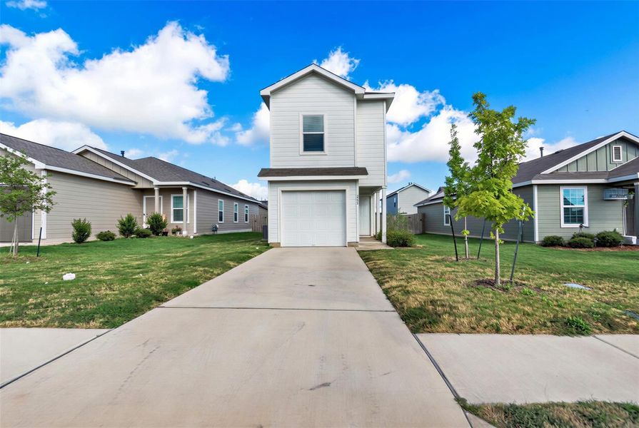 A long concrete driveway leads directly to a neat attached garage beneath classic horizontal siding. A long concrete driveway leads directly to a neat attached garage beneath classic horizontal siding.