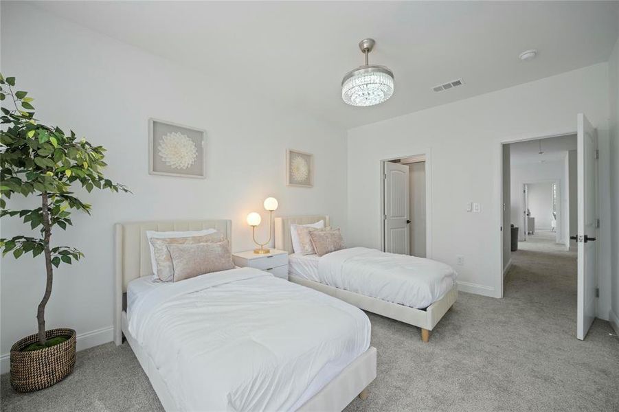 Bedroom with light colored carpet and baseboards