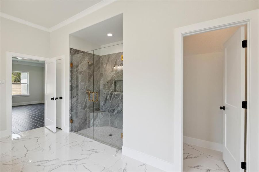 Bathroom with a tile shower, wood-type flooring, and crown molding