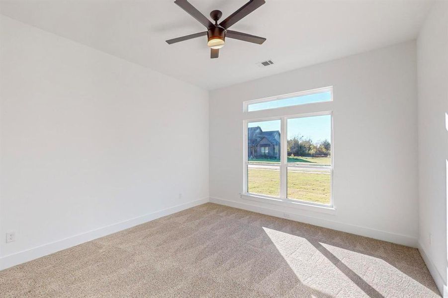 Unfurnished room with light colored carpet and ceiling fan