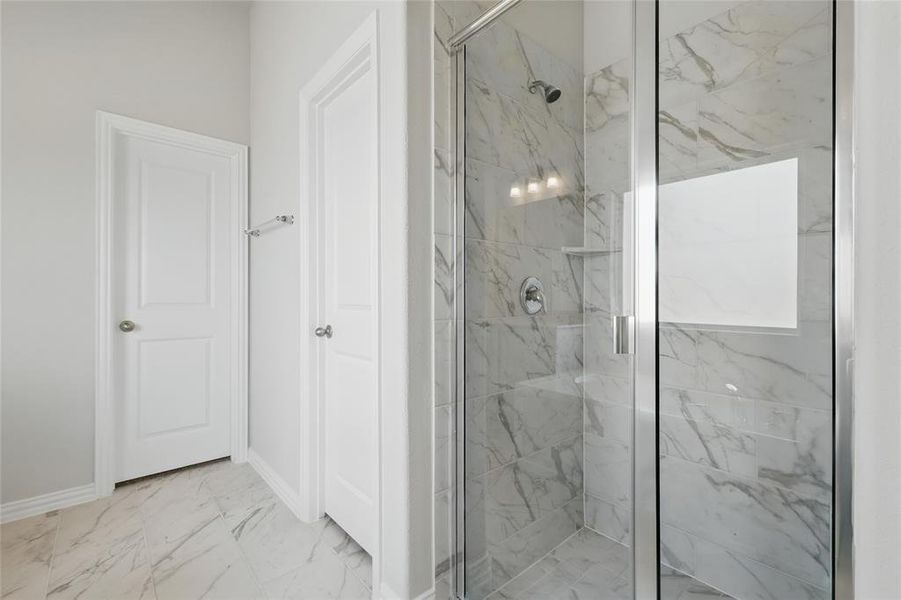 Bathroom with a marble finish shower, marble finish flooring, and baseboards Bathroom with a marble finish shower, marble finish flooring, and baseboards