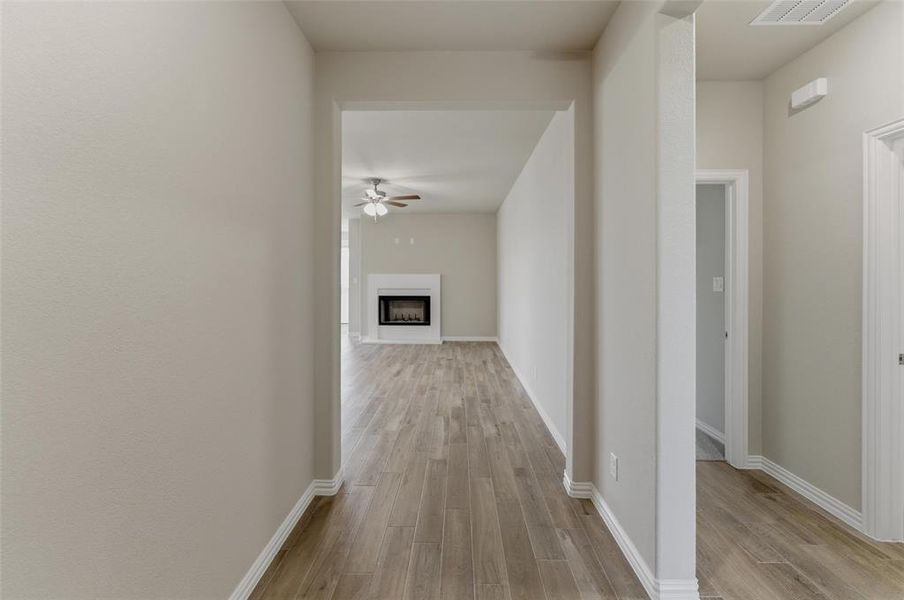 Hallway with wood-finish flooring extending into living space