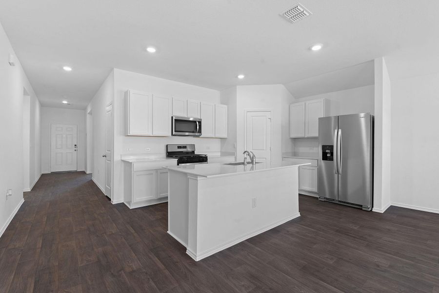 Kitchen featuring appliances with stainless steel finishes, light countertops, visible vents, and white cabinetry