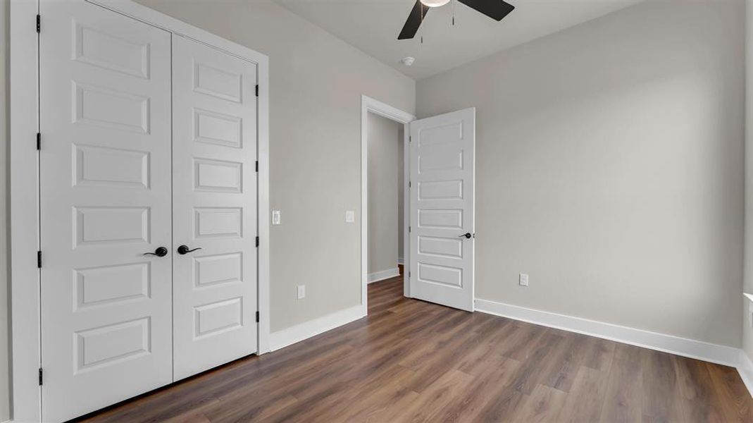 Rich wood-look flooring and crisp white trim enhance this versatile bedroom space. Rich wood-look flooring and crisp white trim enhance this versatile bedroom space.