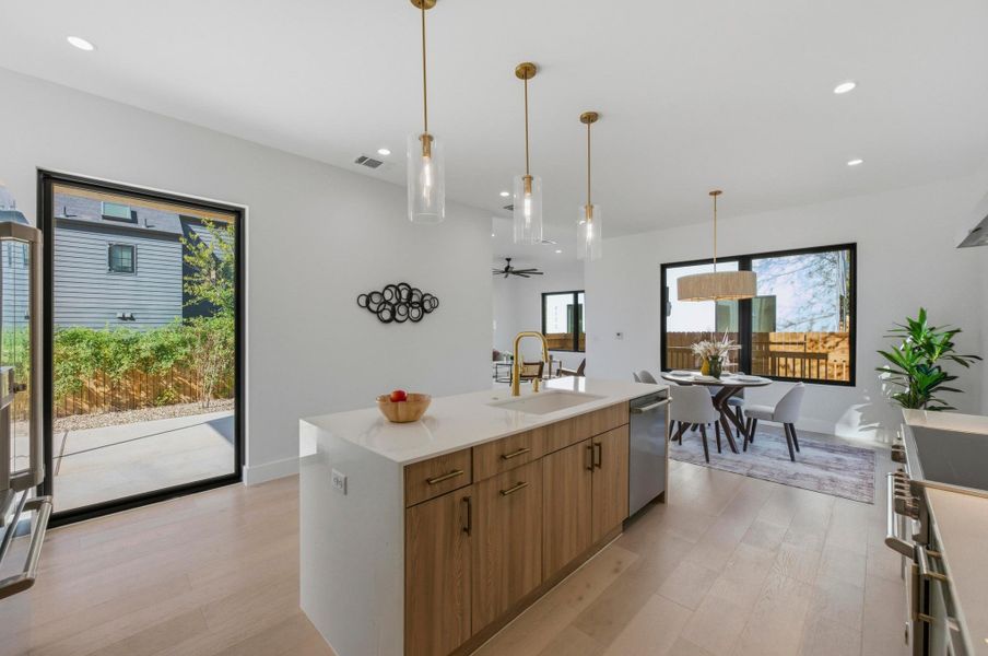 Kitchen featuring light wood-style floors, hanging light fixtures, brown cabinetry, recessed lighting, and ceiling fan