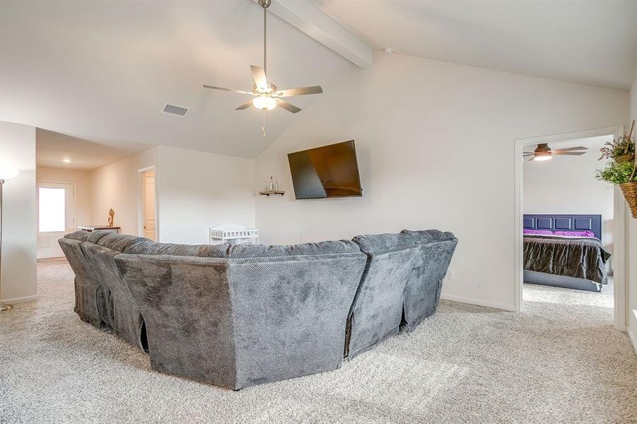 Living area featuring light carpet and a ceiling fan