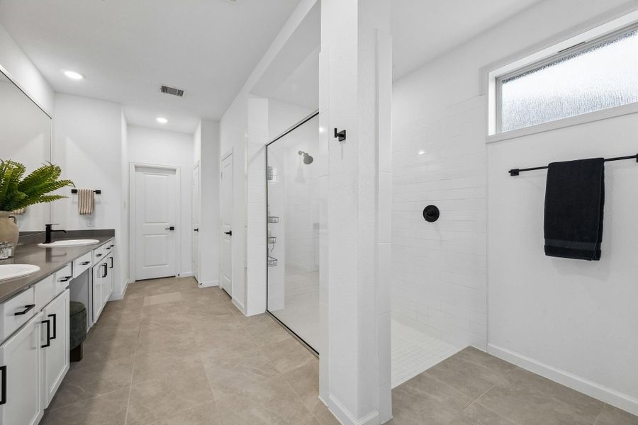 Primary en suite with walk-in shower, dual sinks, vanity and linen closet. Primary en suite with walk-in shower, dual sinks, vanity and linen closet.