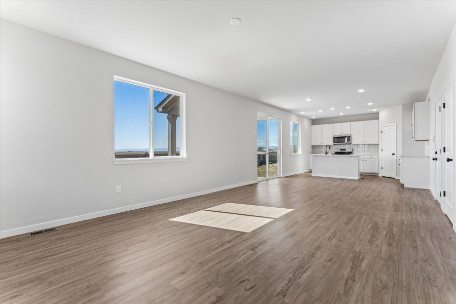 A large empty room with a wood floor and a wood floor.