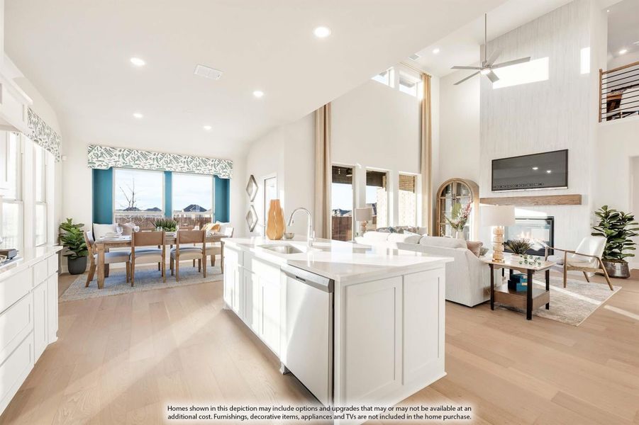 Open-concept kitchen with white island, high ceilings, and views into dining and living areas with fireplace Open-concept kitchen with white island, high ceilings, and views into dining and living areas with fireplace