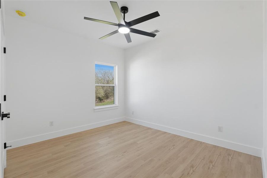 Empty room featuring light wood-style floors and ceiling fan