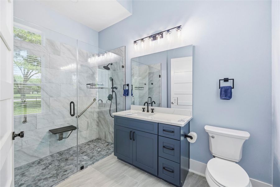Designer guest bath featuring a frameless walk-in shower, marble-look finishes, and sleek modern fixtures.