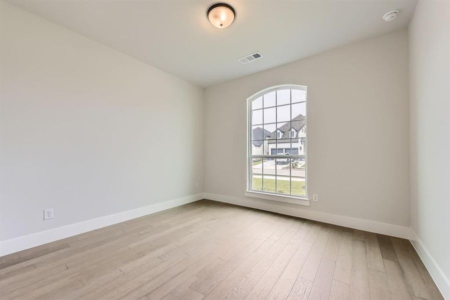 Spare room with light wood-style floors and baseboards
