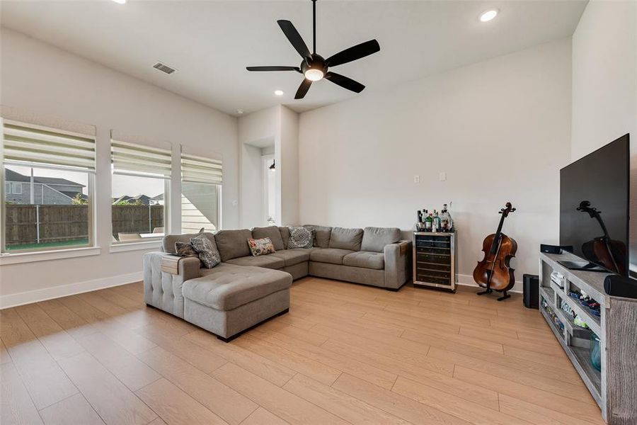 Living area with light wood-style floors, wine cooler, recessed lighting, and a ceiling fan