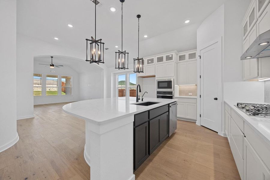 Kitchen with appliances with stainless steel finishes, a ceiling fan, healthy amount of natural light, light wood-style floors, and recessed lighting