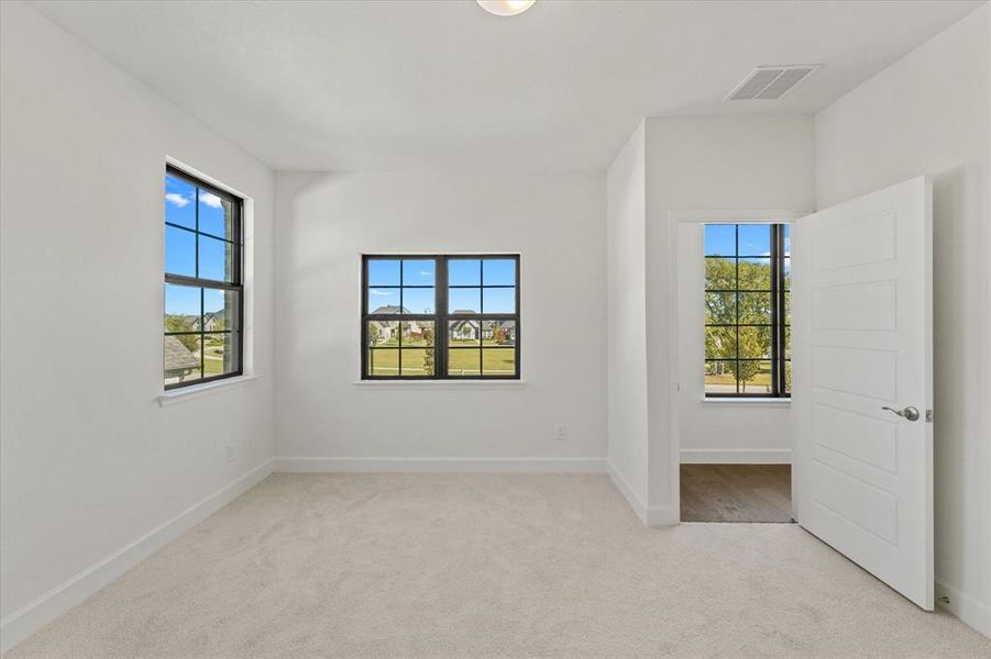 Unfurnished room featuring light carpet and baseboards