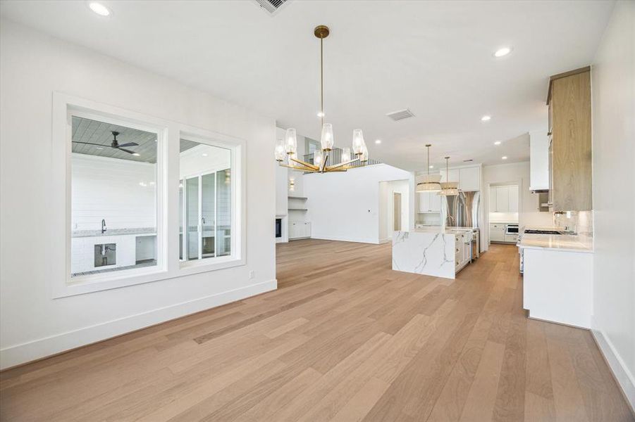 The dining room is tucked just beyond the kitchen and offers views of the lush yard space. All windows in the home are trimmed and cased, all main living areas feature recessed lighting, 8 inch baseboards, wide plank wood flooring and level 4 smooth finish walls. Photo as of 11/5/2024