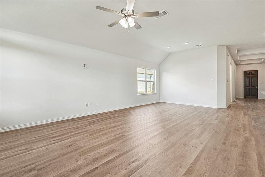 Unfurnished room featuring light hardwood / wood-style flooring, lofted ceiling, and ceiling fan