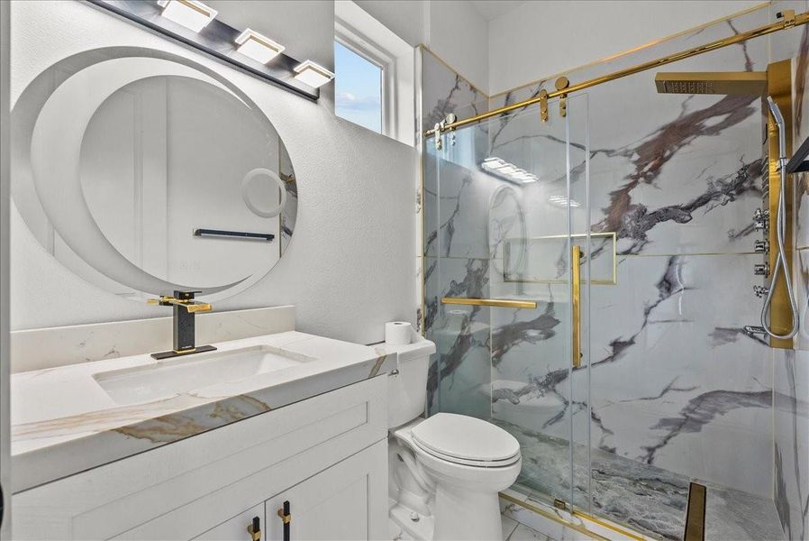 Luxury bathroom with designer lighting, modern vanity, and oversized custom shower.