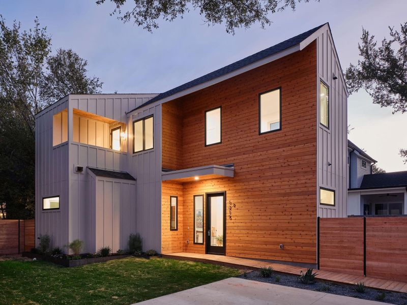 Modern home featuring board and batten siding and a balcony Modern home featuring board and batten siding and a balcony