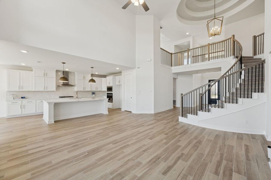 This angle highlights the bright living area with high ceilings and the open-concept design that flows into the kitchen and dining area.