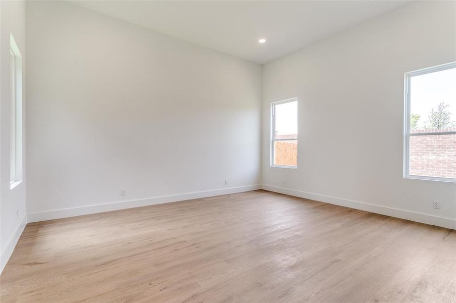 Empty room featuring light wood finished floors and recessed lighting Empty room featuring light wood finished floors and recessed lighting