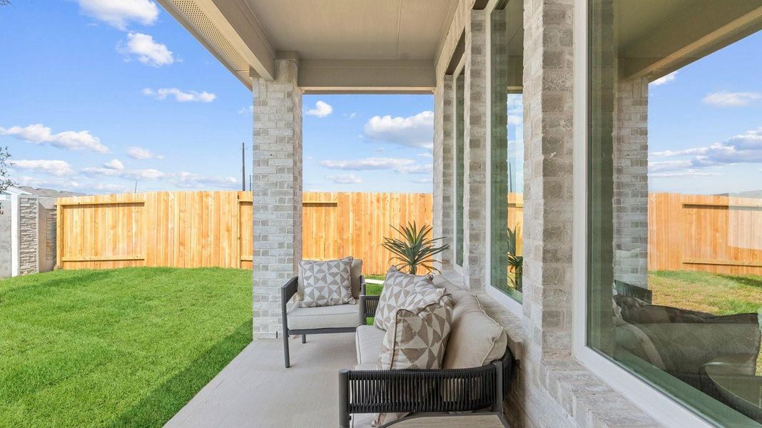 Outdoor covered patio with seating area overlooking a well-maintained lawn, perfect for relaxation. Outdoor covered patio with seating area overlooking a well-maintained lawn, perfect for relaxation.