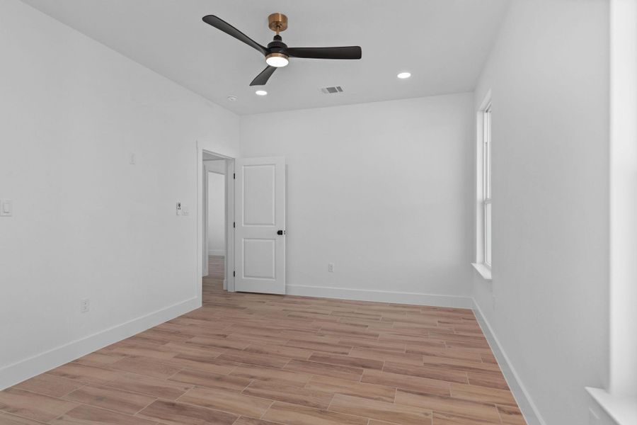 Spare room with wood finish floors, a ceiling fan, and recessed lighting Spare room with wood finish floors, a ceiling fan, and recessed lighting