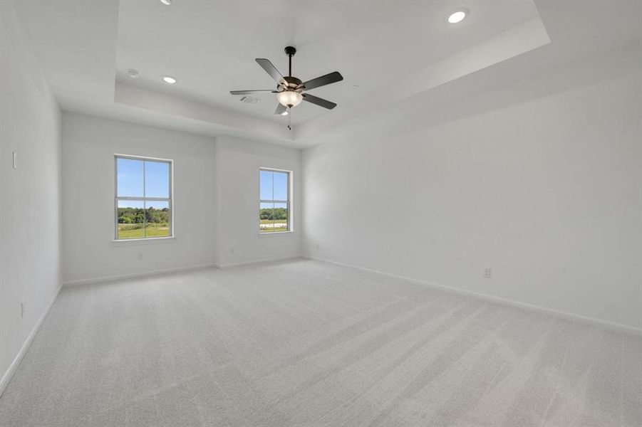 Spacious room featuring light-colored carpeting and white walls Spacious room featuring light-colored carpeting and white walls