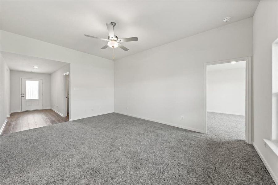 Carpeted spare room featuring ceiling fan