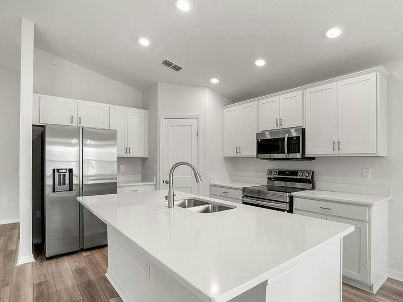 This home features a bright, open kitchen with quartz, 36-inch cabinets, Samsung SS appliances, and a walk-in pantry.