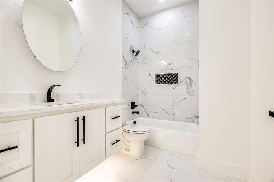 Bathroom featuring vanity, light marble finish floors, and a combined bath / shower with marble appearance Bathroom featuring vanity, light marble finish floors, and a combined bath / shower with marble appearance