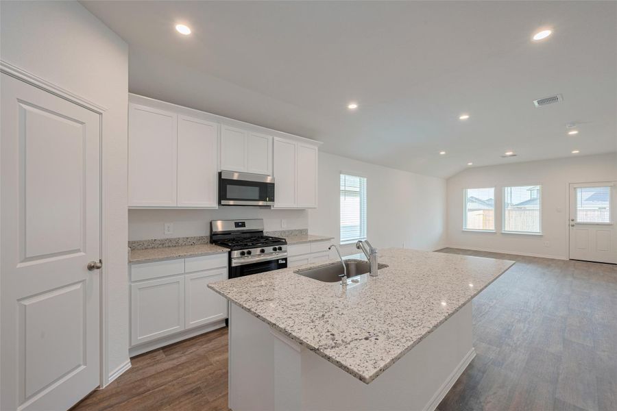 The kitchen centers around a generous island, ideal for casual seating or prep space. The kitchen centers around a generous island, ideal for casual seating or prep space.