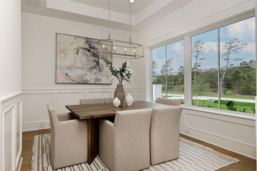 Paneled wainscoting adds depth and style as does the recessed ceiling with fabulous modern linear open frame chandelier.